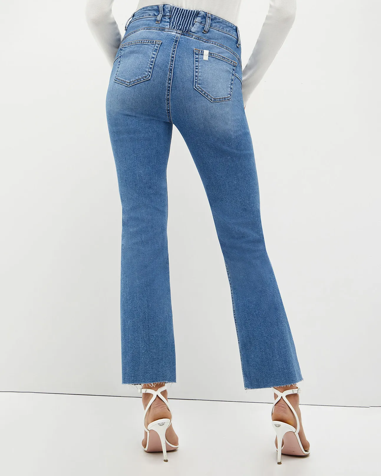 Jeans a vita alta a trombetta in cotone stretch blu super stone washed con elastico in vita sul retro e orli sfrangiati